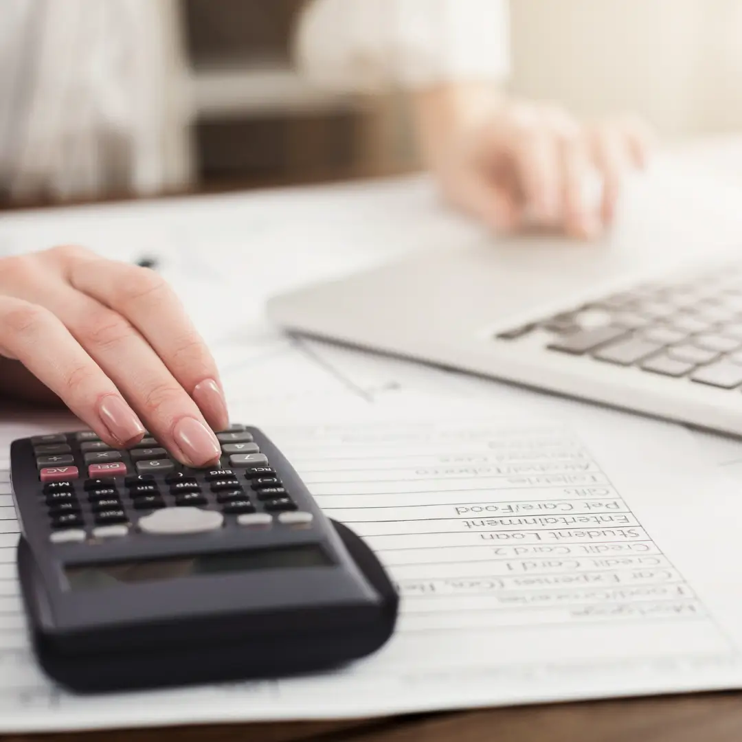 Emprendedor organizando gastos y presupuesto en una hoja contable para separar finanzas personales de las del negocio